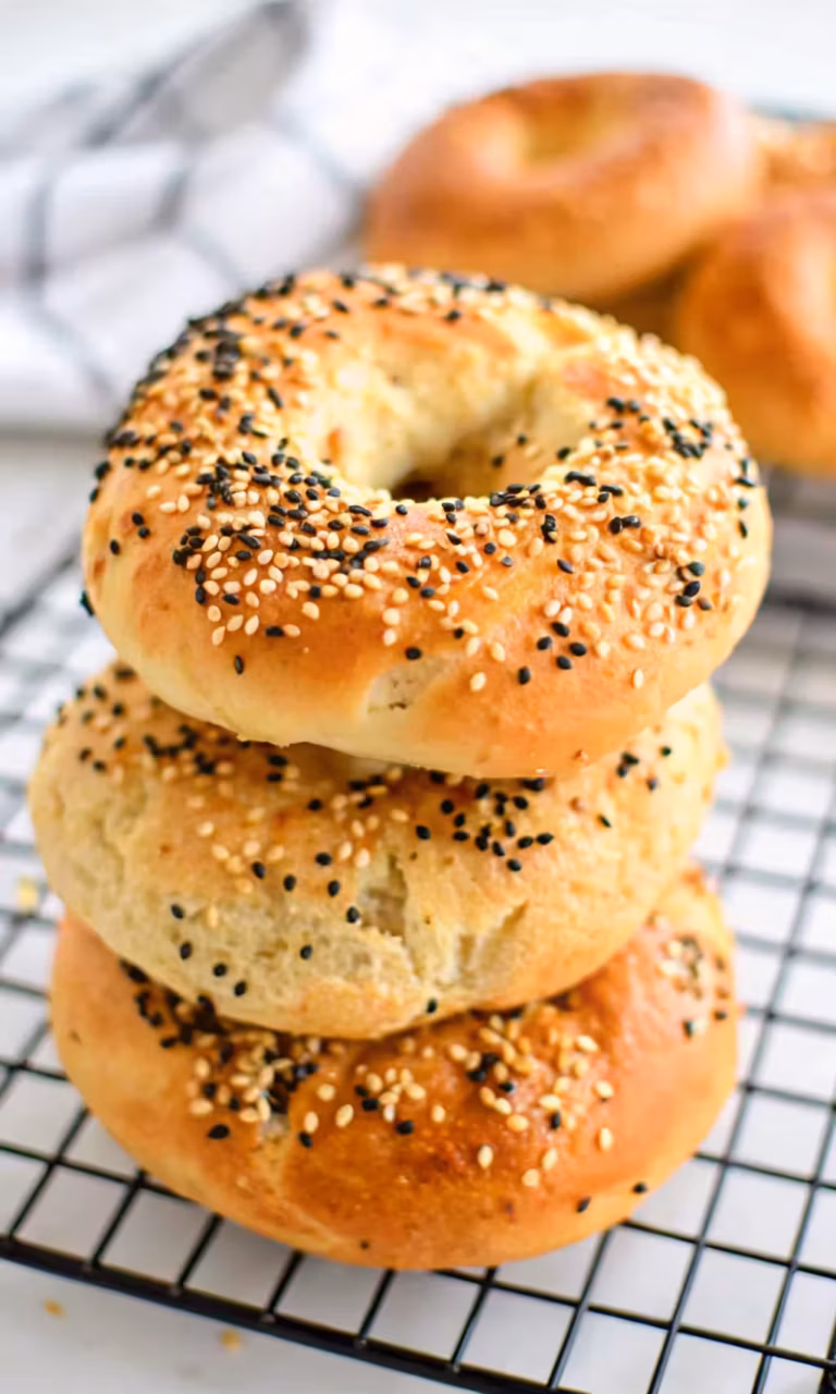 The ultimate two ingredient high protein bagels, golden-brown and topped with everything bagel seasoning, arranged on a rustic board
